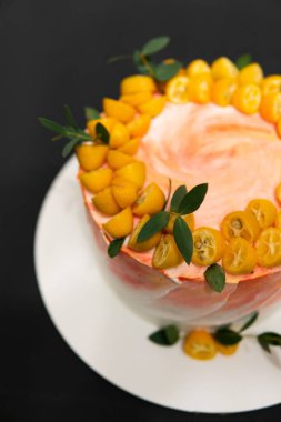 Masada mumlar ve siyah arka planda doğum günü pastası. Koyu ahşap kaplama kremalı taze, lezzetli doğum günü pastası..