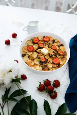 Sağlıklı kahvaltı kavramına sahip gözleme ya da börek, beyaz tabakta çilek ve yabanmersini reçeli ahşap kırsal masa çeşitli sabah yemekleri - Amerikan krepleri yığını