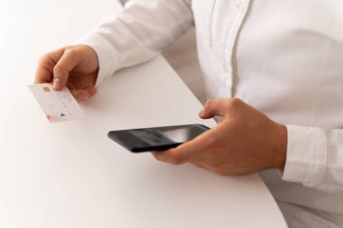 Sabah ışığında online alışveriş konsepti. Çevrimiçi ödeme, akıllı telefon ve sosyal güvenlik kartı online alışveriş için akıllı telefon kullanımı. Kredi kartı ve iş adamı elleri