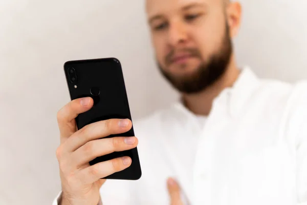 Крупный план молодого человека, делающего мужские руки с помощью смартфона и держащего кредитную карту с соцвыплатой — стоковое фото