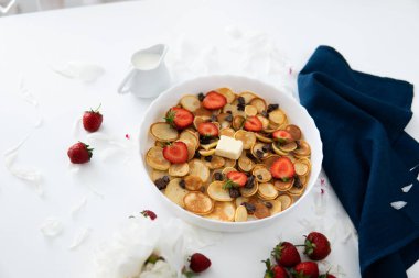 Bir yığın Amerikan sabah yemeği - krep ya da sağlıklı kahvaltı konsepti olan börek, ahşap kırsal masada beyaz tabakta çilek ve yaban mersini reçeli