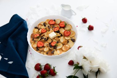 Bir yığın sağlıklı amerikan kahvaltısı konsepti, beyaz tabakta çilek ve yabanmersini reçeli ahşap kırsal masa çeşitli sabah yemekleri ile süslenmiş krep veya börek