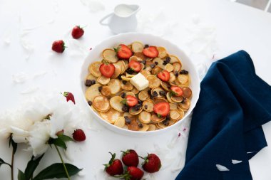 Bir yığın amerikan ahşap rustik masası çeşitli sabah yemekleri süsledi - krep ya da börek üzerine sağlıklı kahvaltı konsepti, çilek ve yaban mersini reçeli beyaz tabakta