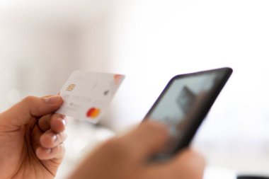Sabah ışığında online alışveriş konsepti. Genç adamın akıllı telefon kullanarak el ele tutuşması ve sosyal ödemeyle birlikte iş yerinde internet üzerinden akıllı telefon kullanması..