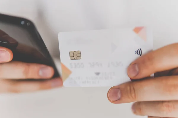 Closeup of young man making man hands using smartphone and holding credit card with social Payment online shopping smartphone at working place. Online shopping concept in morning light.