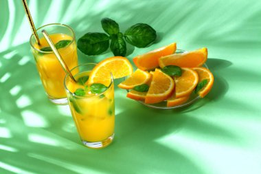 Yeşil palmiye yaprakları ile portakal suyu