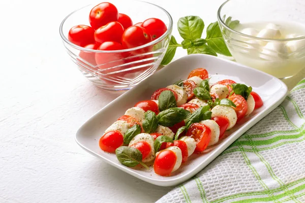Ensalada Caprese. Tomates, albahaca, mozzarella y aceite . — Foto de Stock