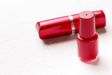 Beyaz arka planda tırnak cilası ve ruj.