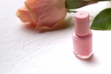 Beyaz arka planda tırnak cilası ve ruj.