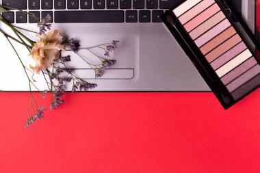 Masada çiçek ve kozmetik ile Laptop. Serbest çalışan çalışma alanı.