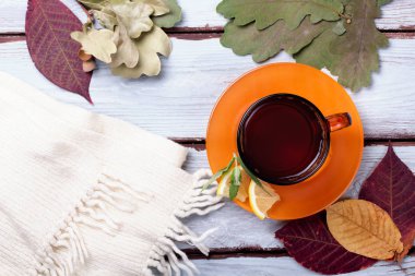 Sonbahar yaprakları ile ahşap bir arka plan üzerinde çay fincan. Üstte görüntü.