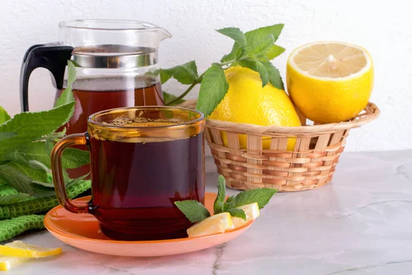 Vaso de té con menta y limón sobre mesa de mármol . — Foto de Stock