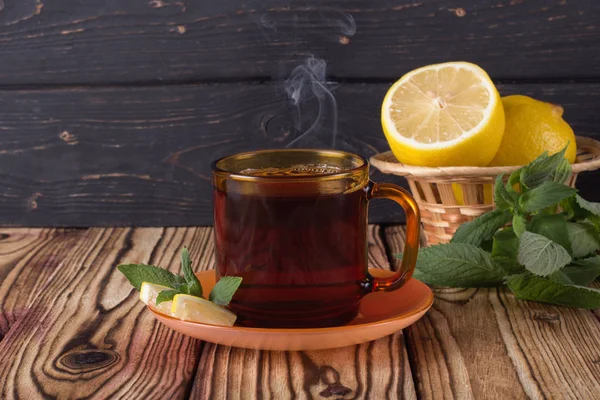 Sonbahar yaprakları ile ahşap bir arka plan üzerinde çay Fincan. 