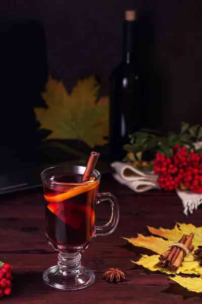 Copa de vino caliente en una mesa de madera con canela . — Foto de Stock