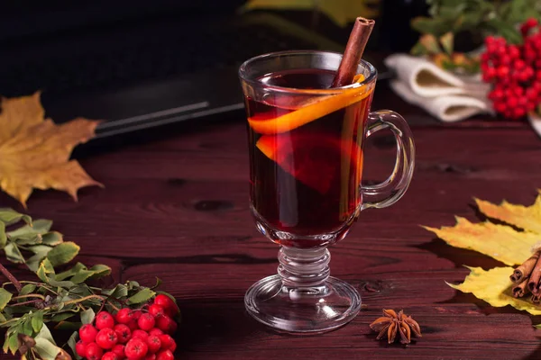 Copo de vinho quente em uma mesa de madeira com canela . — Fotografia de Stock