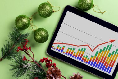 Masaüstünde iş grafiği olan bir tablet. Noel süslemeleri.
