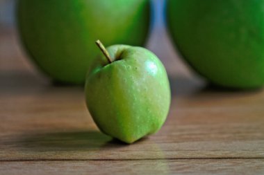 Ahşap bir masa üzerinde küçük yeşil elma