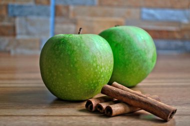 İki yeşil elma ve tarçın bir ahşap tablo