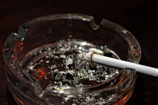 Lit Cigarette Clear Ashtray — Stock Photo, Image