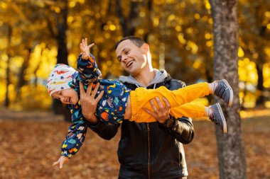 Mutlu baba sonbahar parkında oğluyla oynuyor. Sonbahar konsepti, sonbahar sezonu, sonbahar