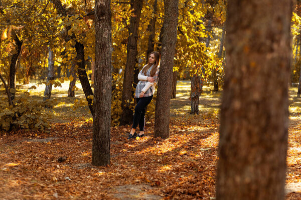 Smiling woman relaxing in a colorful autumn park or  forest, autumn concept, autumn season, fall