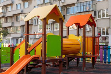 Colorful and empty children's playground with slides, swings, and climbing frames in a residential area, a bright and fun place for outdoor activities and summer games