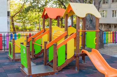 Parktaki oyun parkı. Güneşli bir günde, büyük, renkli, kaydırak ve tırmanma çerçeveli bir oyun alanı.