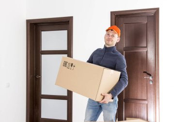 çalışan hizmet daire onun elinde karton kutu ile hareket etmek için. Yer değiştirme hizmetleri adam. Taşıyıcı holding daire kutusunda. teslimatçı parsel ile.