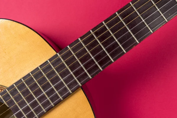 Akustik gitar bir pembe yakın çekim.