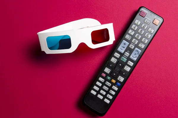 Film auf 3d tv. Filme ansehen. 3D-Brille und Fernbedienung vom Fernseher auf rosa Hintergrund. — Stockfoto