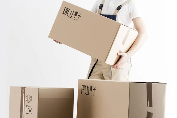 Visão de close-up de mover segurando caixa de papelão isolado em fundo branco. Conceito de mudança para uma casa nova. Carregador com caixas . — Fotografia de Stock