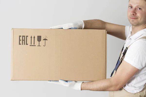 Fee shipping man. Delivery man courier holds cardboard box in hands