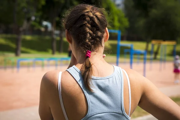 Gadis pas di lapangan olahraga dengan bar horisontal dan trek berjalan. Wanita muda pada latihan kebugaran aktif . — Stok Foto