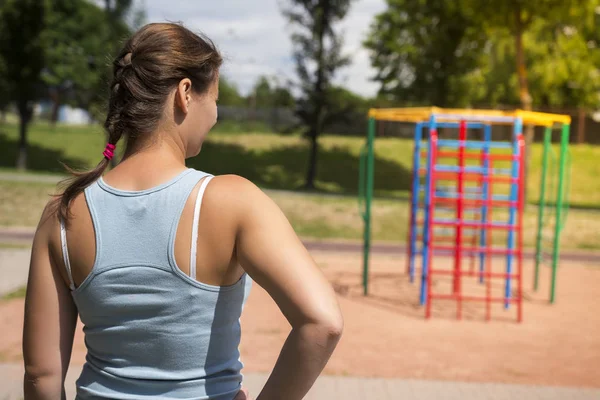 Молодая женщина на спортивной площадке в яркий летний день. Девушка идет заниматься спортом и фитнесом — стоковое фото
