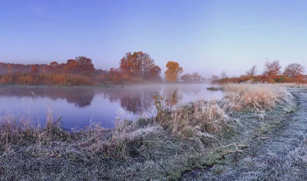 Herbstliche Naturlandschaft mit frostigem Novembermorgen am Flussufer mit Raureif auf Gras und Bäumen. Ruhige Landschaft Herbst mit roten und gelben Blättern auf Ästen von Bäumen am Ufer des Flusses. — Stockfoto