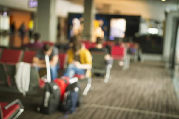 Fundo desfocado dos passageiros nos assentos na sala de espera do aeroporto antes da partida . — Fotografia de Stock