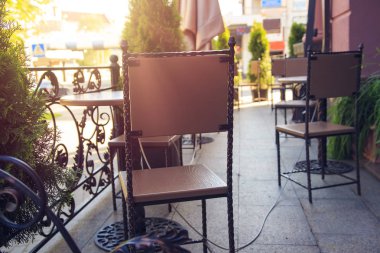 İç parlak yaz gününde bir sokakta bir kafe. Sandalye ve masa sokak Cafe.