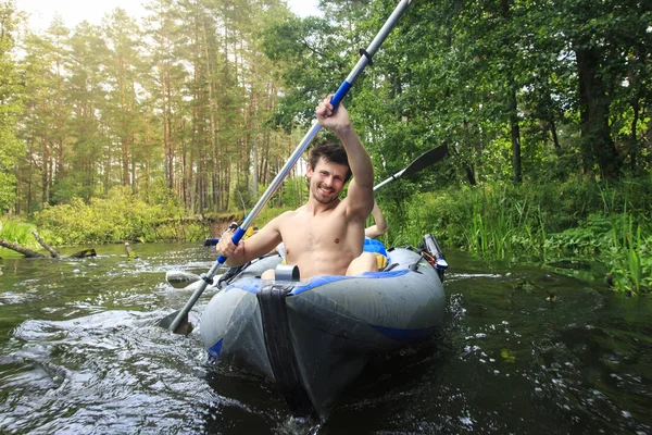 Rafting im Kanu auf dem Fluss. Junge Burschen mit Rudern in einem Boot segeln im Sommer auf dem Fluss. Aktiv Rafting auf dem Fluss. Sportlicher junger Mann im Kajak mit Ruderruder auf dem Wasser. — Stockfoto