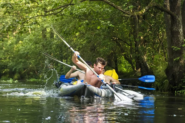 kayaking and canoeing on river. Rafting along river on kayak. Athletic men in boat. Active rest on outdoor. Adventure trip. Group of people in canoe.