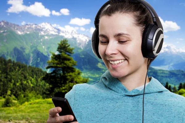 Meisje met de speler en de koptelefoon op een heldere zonnige dag op de berg natuur landschap-achtergrond pop muziek beluisteren. — Stockfoto