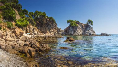 Kaya, taş ve deniz kıyısında İspanyolca Akdeniz, Bay Lloret de Mar, Costa Brava, İspanya görünümü harika. Deniz manzarası kayalık deniz Beach yaz gününde. Dağlar deniz doğa manzara.