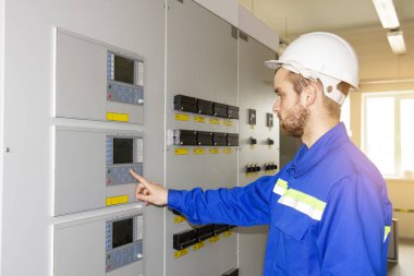 Kumanda panosu üzerinde elektrikçi mühendis. İşçi endüstriyel proseslerin denetler. Kontrol makineleri için Otomasyon noktası. Yüksek teknoloji enerji