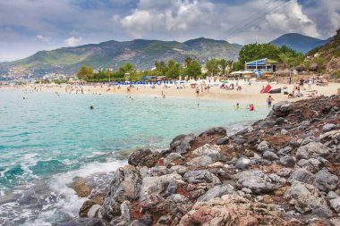 Alanya, Türkiye'de kum plajındaki görüntüleyin. Alanya'da Kleopatra Plajı. Türk tatil. Akdeniz'in yaz tatili. Güneşli gün sahilde turistler.