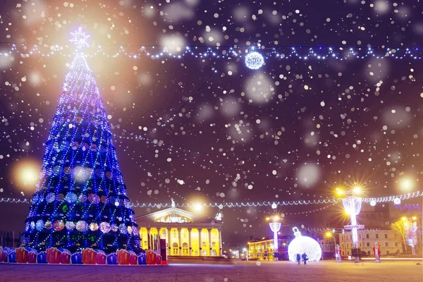 Gece şehir Noel'de. Aydınlatmaları ve gece cityscape süslemeleri. Ünlü Meydanı'nda süslenen Noel ağacı. Kış kutlamalar arka plan. Işıklar gece sokakta parlak ve parlak.