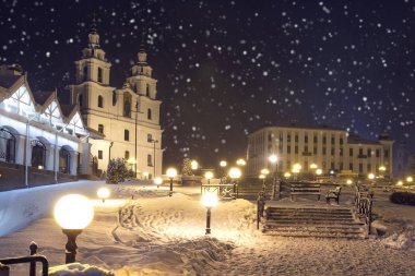 Minsk, Beyaz Rusya Kış masal. Katedrali Kutsal Ruh'un kökenli Noel arka plan. Gece cityscape kar yağışı içinde. Kar taneleri düşüyor. Karlı gece Minsk.