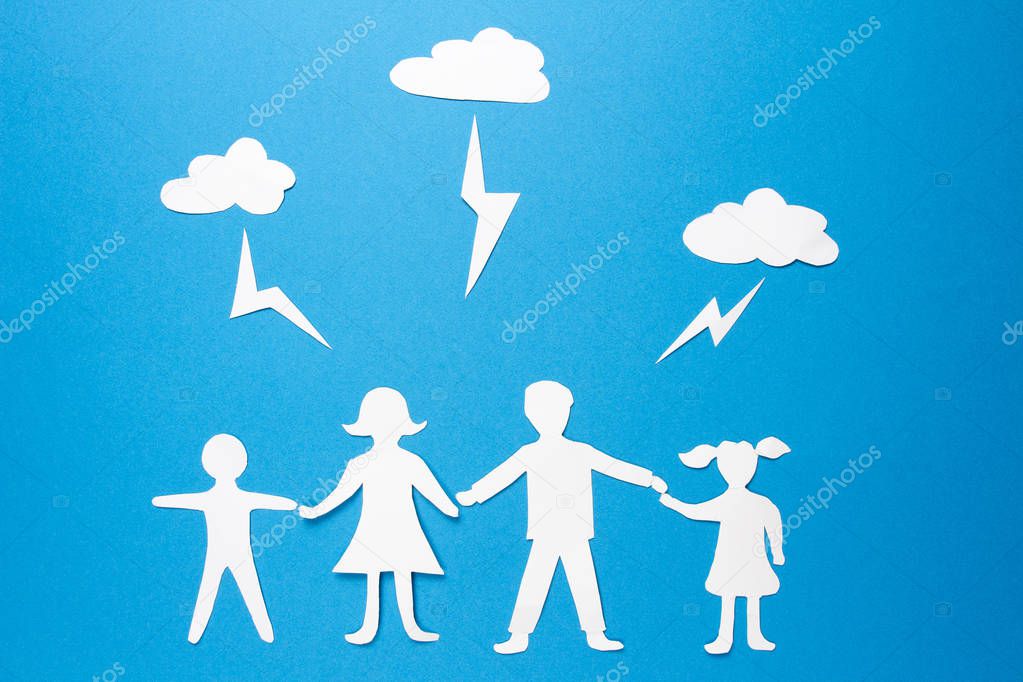 Family insurance concept. Paper origami father, mother, son and daughter are holding hands under lightning strikes.