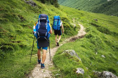 Hiking trail Svaneti bölgesi, Georgia. Trek dağ iki yürüyüşçü erkekler yürümek. Sırt çantaları turistlerle dağlarında yürüyüş. Dağlarda trekking. Tepeler ve bağlar spor turizm