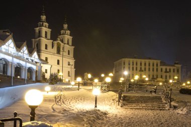 Kış Minsk, Beyaz Rusya. Karlı gece cityscape Noel zamanında. Fotoğraf Katedrali Kutsal Ruh'un kökenli. Şehir ışıkları ve fenerler tarafından aydınlatılmış.