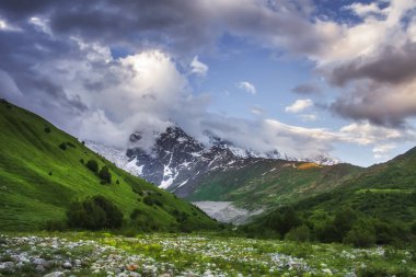 Svaneti dağ manzarası, Georgia. Caucasus vahşi doğa ile karlı rocky Dağları ve çimenli tepeler. Bulutlu gökyüzü günbatımı bağlar tepeler üzerinde. Doğal dağlar. Gürcü Vadisi. Highlands.