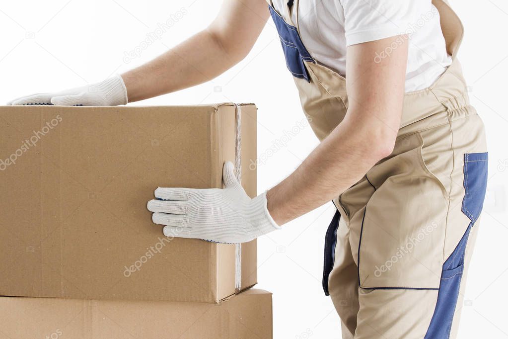 Loader in uniform with cardboard boxes closeup. Mover at work. Relocation man with box. Delivery man puts boxes.